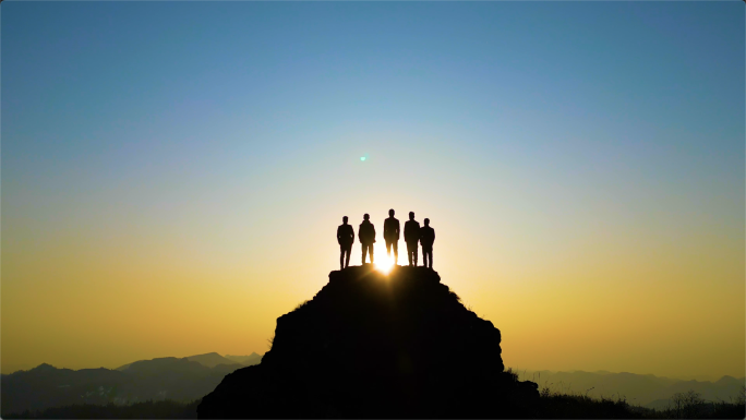 创业团队登山山峰站在山顶眺望远方背影剪影
