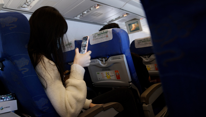 美女在飞机上学习 玩手机看手机 看杂志