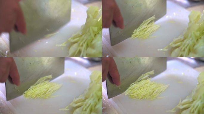一位专业厨师在砧板上快速切白菜细丝