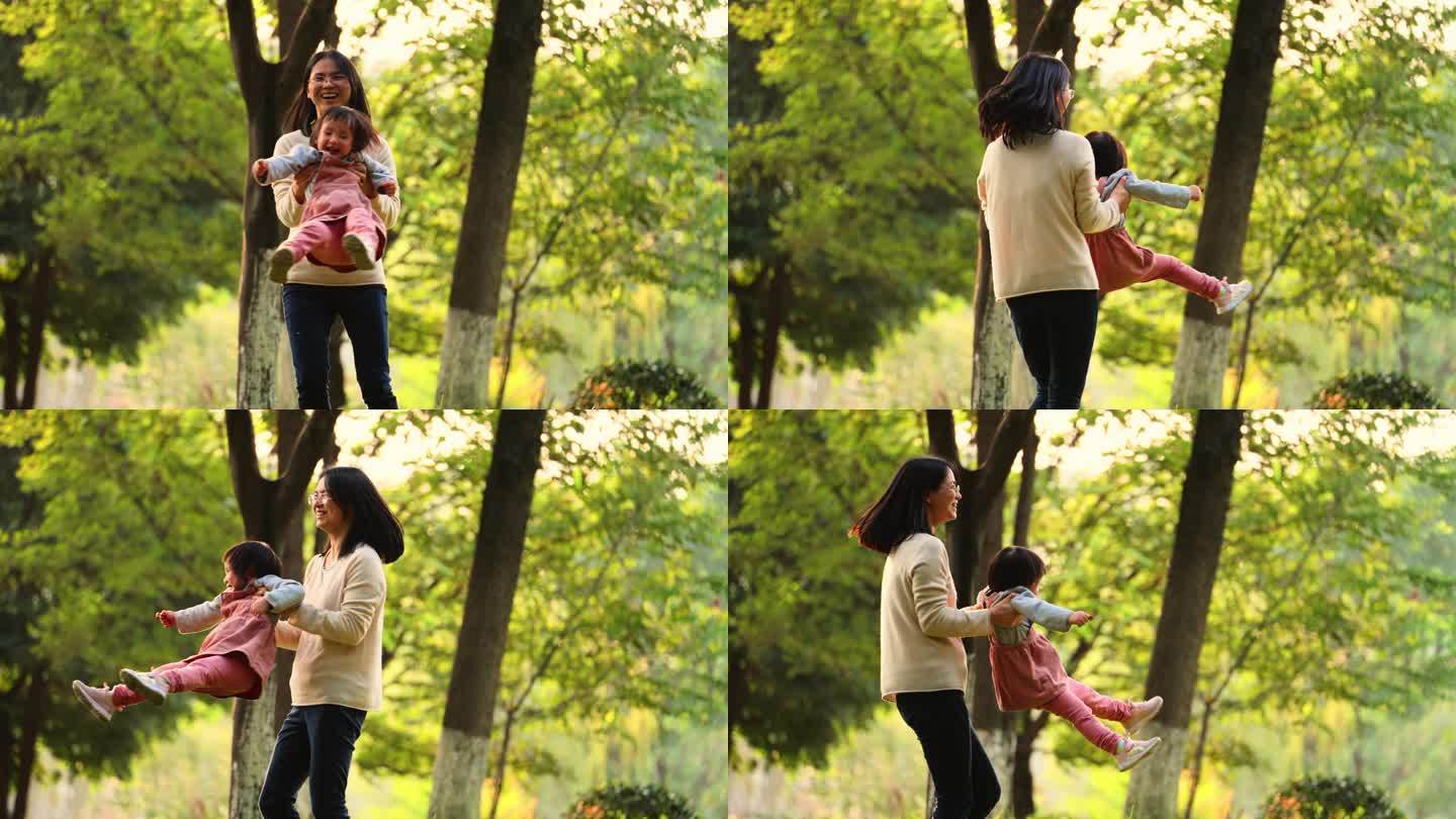 秋天公园里亲子欢乐时光妈妈抱着宝宝转圈