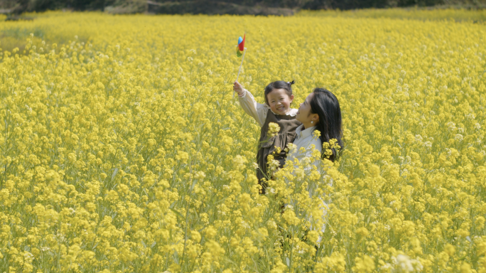 妈妈带孩子在油菜花里奔跑