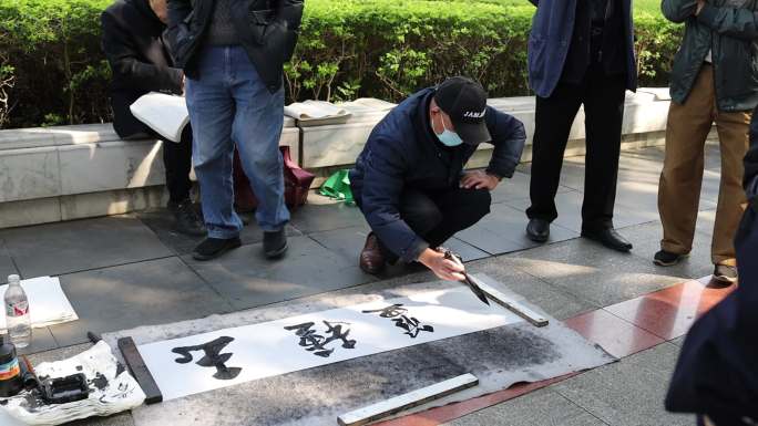 退休老人广场街头写毛笔字