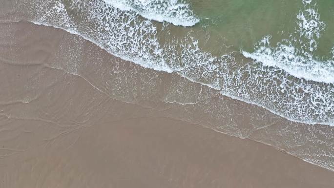 海浪后浪拍前浪消失在沙滩上