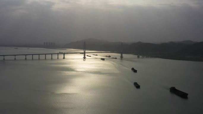 早晨日出时江边大桥下船只运输通过桥梁桥洞