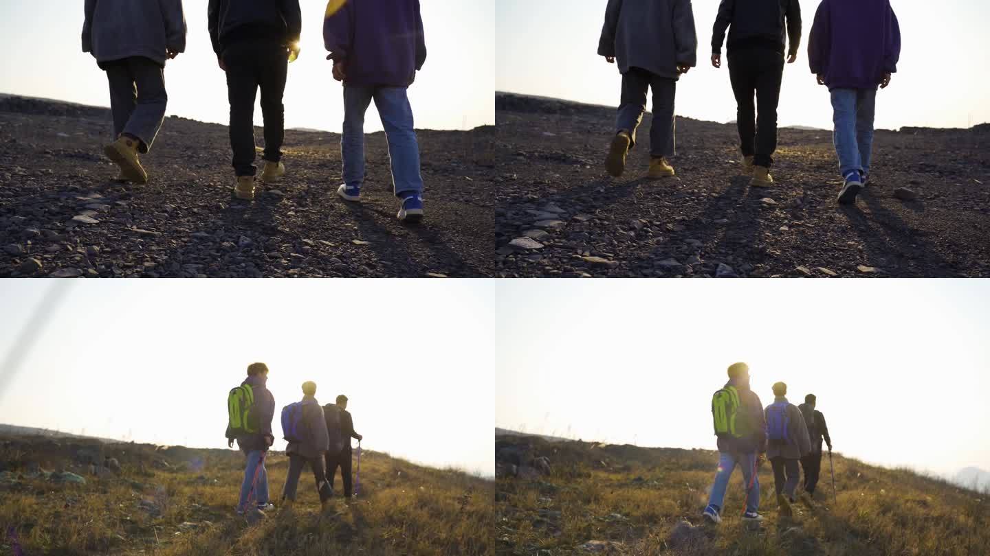 一群人山顶夕阳逆光徒步前行剪影登山包