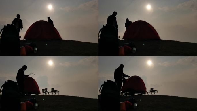 夕阳下安装帐篷剪影