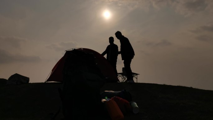 夕阳下安装帐篷剪影