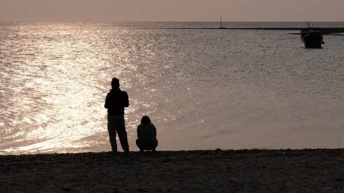 夕阳下的海边情侣