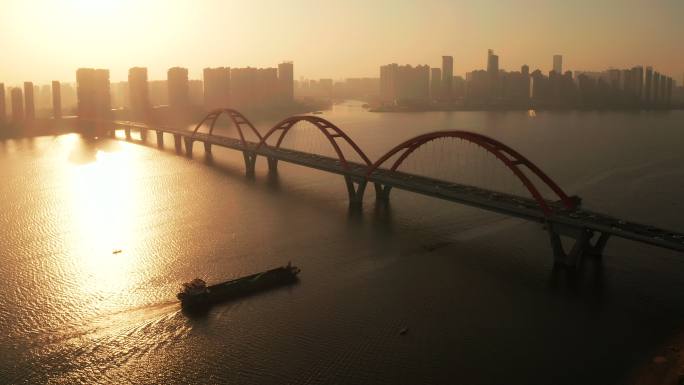 清晨唯美日出下轮船驶过长沙福元路大桥