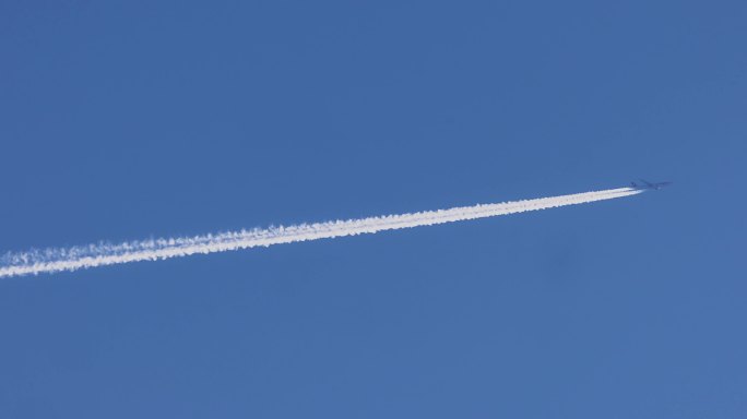 蓝天上拖尾飞行的飞机