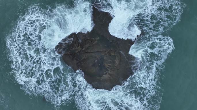 蓝色大海中礁石俯拍海水拍打岩石浪花泡沫