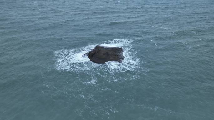 蓝色大海中礁石俯拍海水拍打岩石浪花泡沫