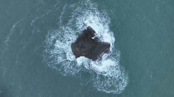 蓝色大海中礁石俯拍海水拍打岩石浪花泡沫