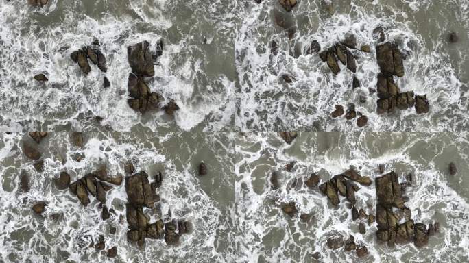 大海俯拍礁石浪花海水拍打礁石阴天海水浑浊