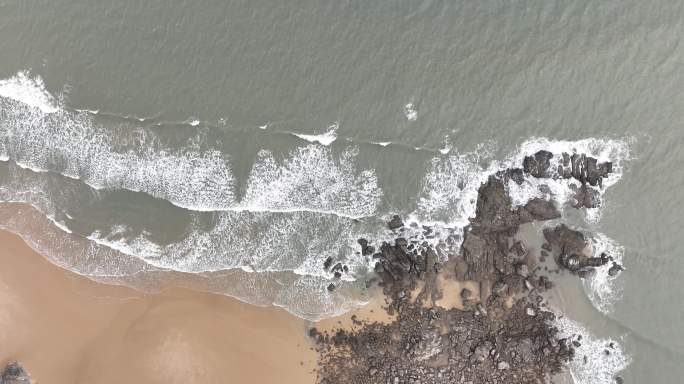 大海俯拍礁石浪花海水拍打礁石阴天海水浑浊