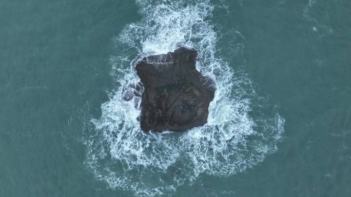 蓝色大海中礁石俯拍海水拍打岩石浪花泡沫