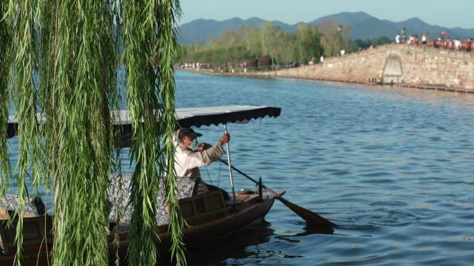 杭州西湖断桥边小船从杨柳前划过