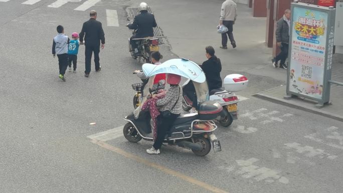 小学生在路上骑电动车