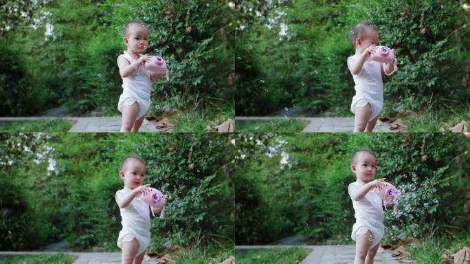蹒跚学步的可爱小婴儿在公园里玩耍吹泡泡