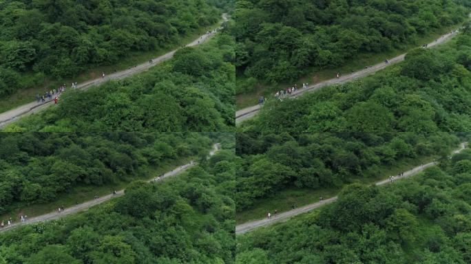 夏日九顶山一群户外徒步游客走在小路上