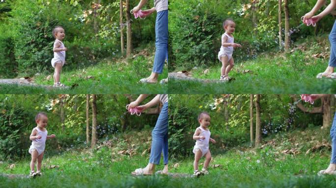 幼儿刚会走路公园里玩泡泡蹒跚学步