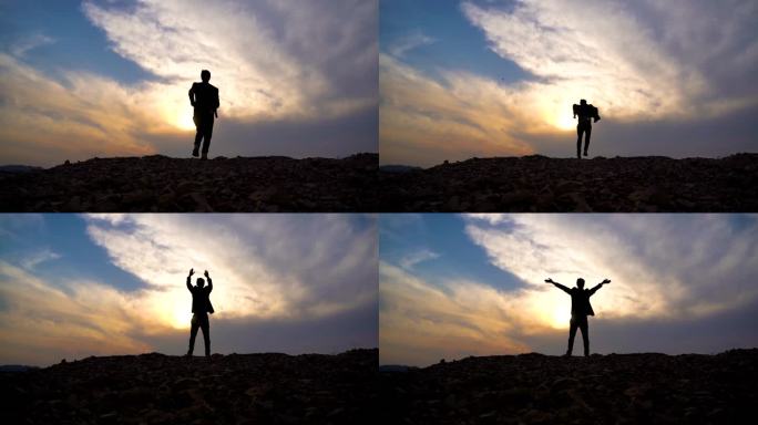 西装男士山顶逆光奔跑眺望远方