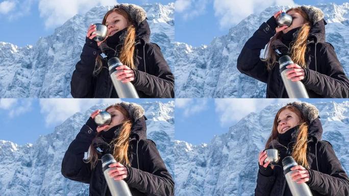 女人在雪山的热水瓶里喝酒