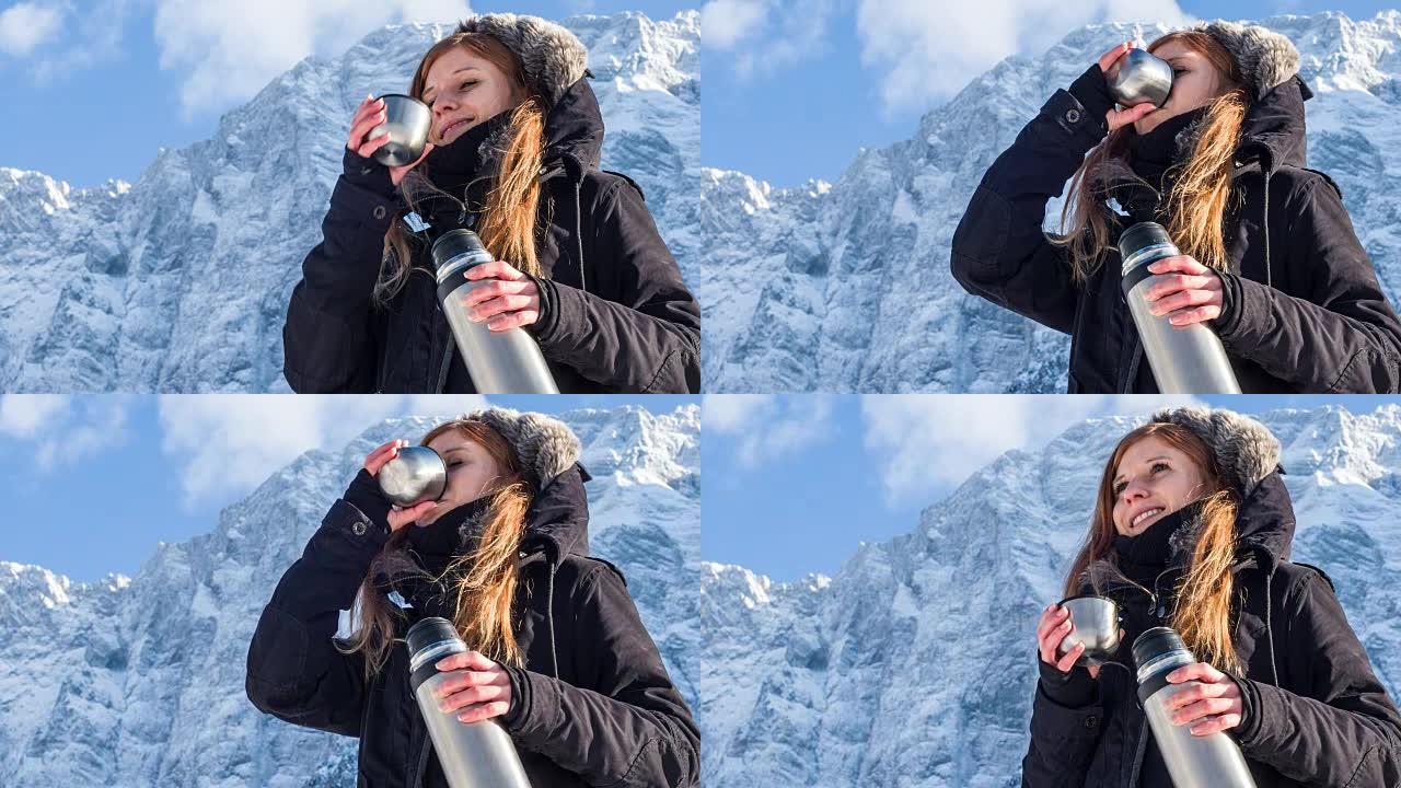 女人在雪山的热水瓶里喝酒