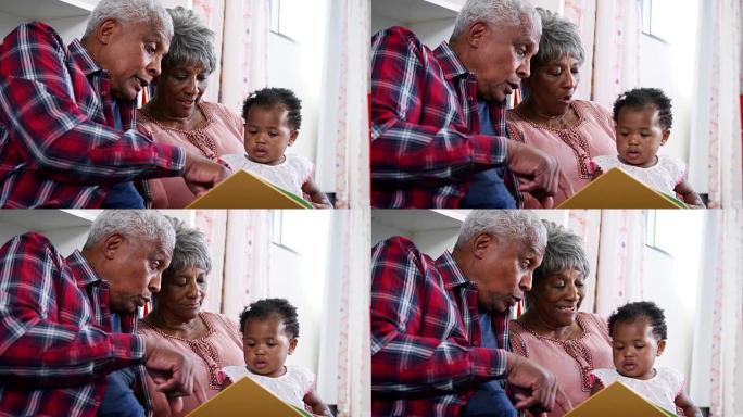 祖父母坐在家里和小孙女一起看书