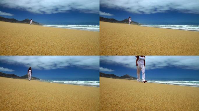 走在海滩上的女人海岸线独自行走的女人海滩
