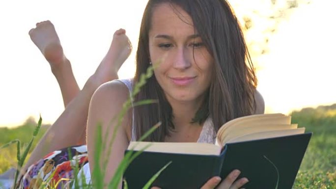 农民快乐的女孩在草地上读书显示了周围自然的幸福。