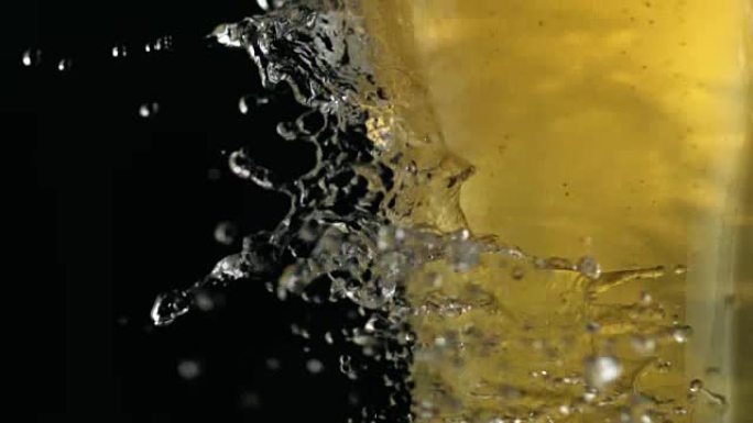 水滴落在装满啤酒的杯子上。新鲜隐喻