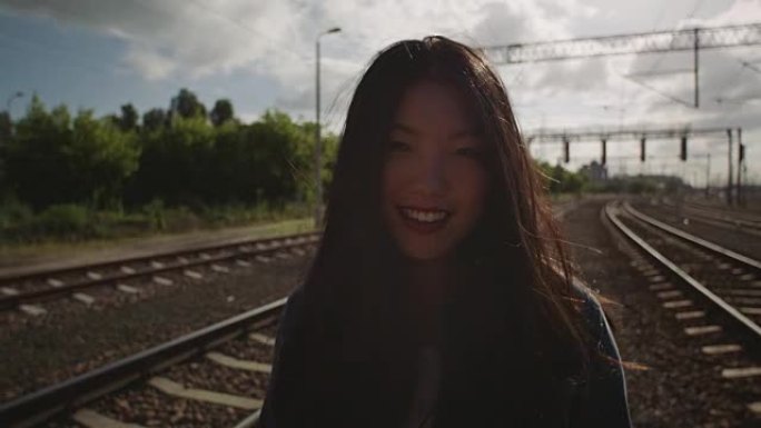 亚洲年轻女子在铁路上反语。