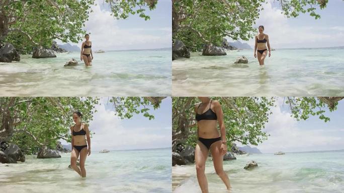 穿着比基尼的女人在私人海滩上穿水