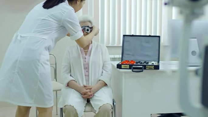 女眼科医生将试验架放在患者脸上