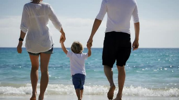 海滩上的家人呵护儿童成长一家三口旅游