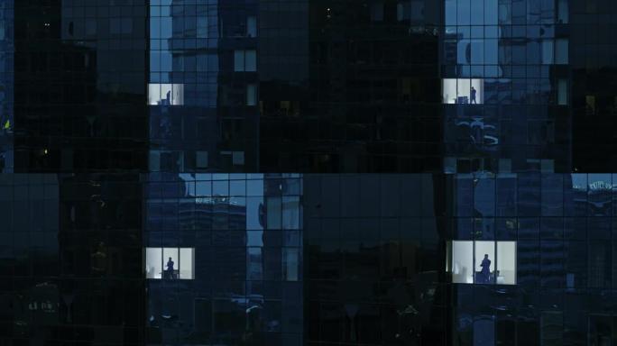 鸟瞰图: 从外面进入办公楼，商人使用手机并站在办公室窗户旁。美丽的撤退飞拍金融商务区摩天大楼。