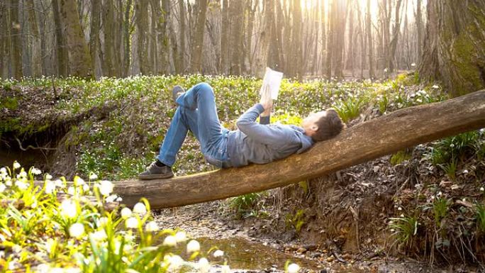 DS男子躺在树干上看书