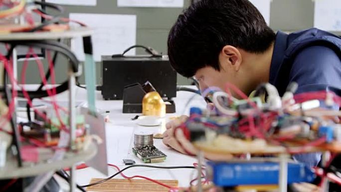 青少年在学校机器人俱乐部项目中研究功能齐全的可编程机器人。创意设计师在车间测试机器人原型。科学概念