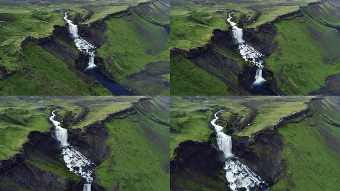 在冰岛山区流淌的巨型两层瀑布的航拍