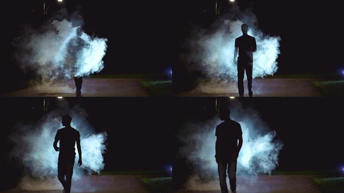 男性走在黑暗背景上的烟雾云附近，慢动作
