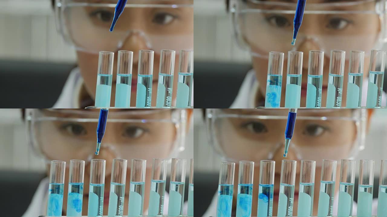 用移液器分析彩色液体以提取试管中的DNA和分子的科学家特写