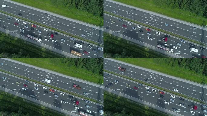 自上而下: 在高速公路上拥堵的无数汽车和卡车上方飞行。