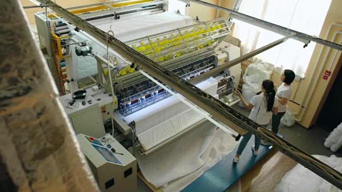 在工厂使用纺织机的女性操作员