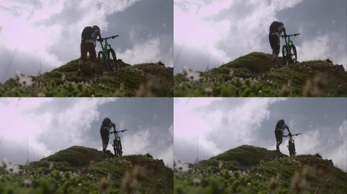 登山自行车手推着自行车上坡