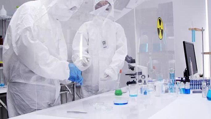 工程师/科学家/技术员穿着无菌服在现代半导体制造工厂工作。医学病毒学研究科学家在防护服和口罩工作。男