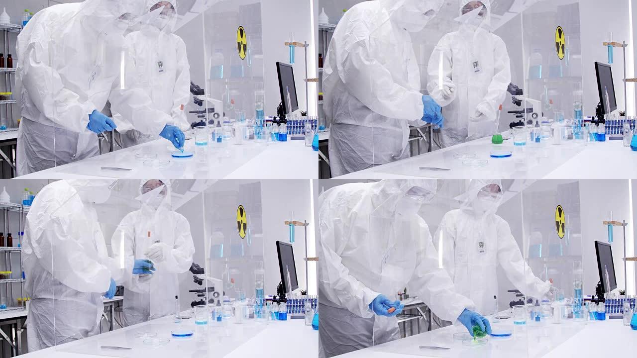 工程师/科学家/技术员穿着无菌服在现代半导体制造工厂工作。医学病毒学研究科学家在防护服和口罩工作。男