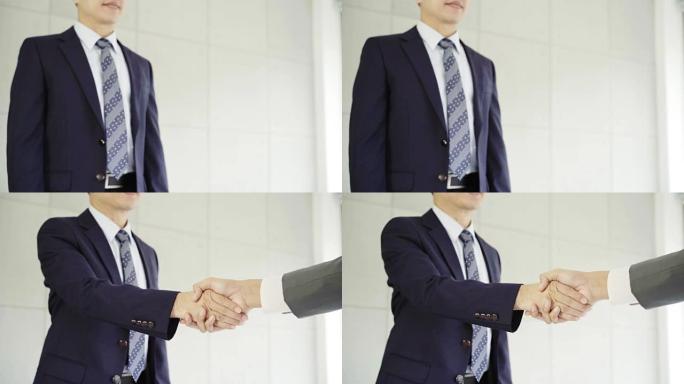 慢动作-求职会议后握手达成协议。两位亚洲自信的商人在办公室开会时握手，成功，交易，问候和合作伙伴概念