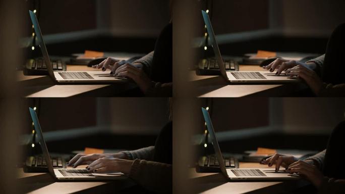 特写女人晚上用笔记本电脑工作。女性手使用笔记本触摸板和触控板。工作狂。4K