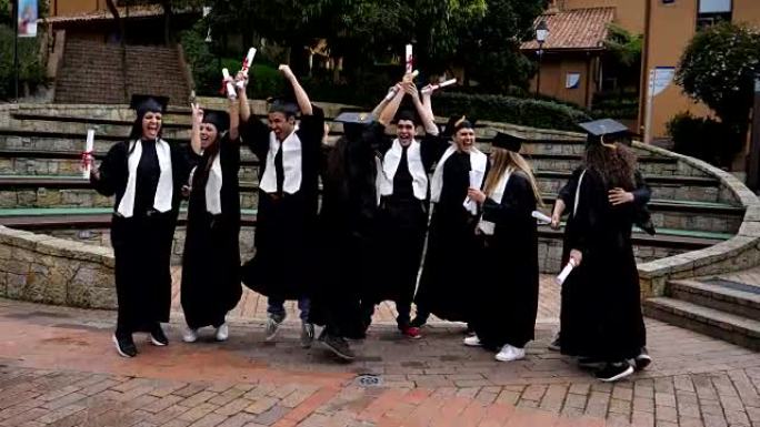 拉丁美洲兴奋的年轻人庆祝他们刚刚毕业拥抱和跳跃